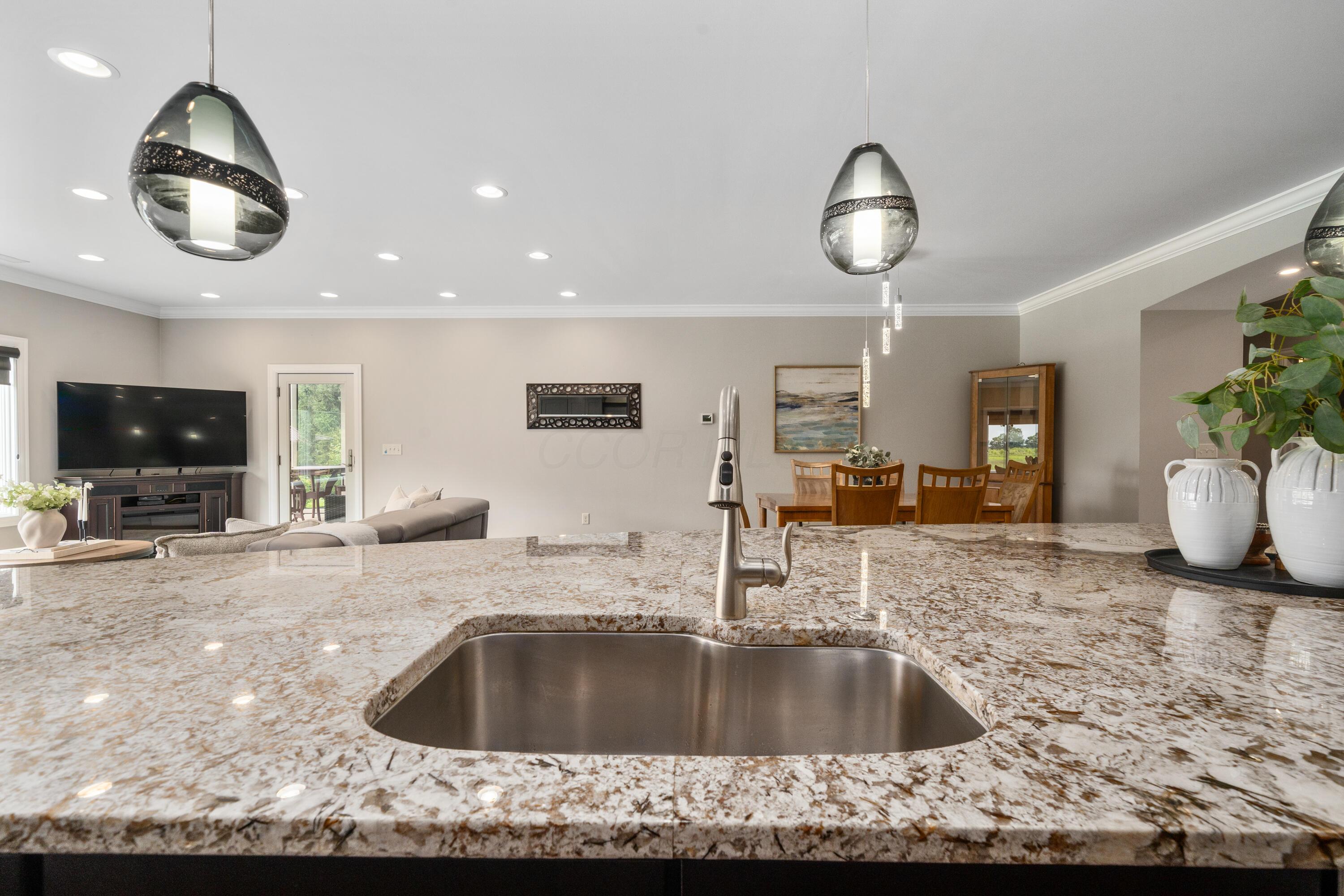 4640 Maynard Road Delaware, OH 43015 - Photo 15 of 91 Spacious kitchen island featuring a stainless steel undermount sink and a brushed nickel pull-down faucet