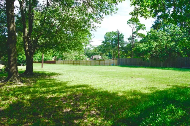 a view of green field with trees in the background