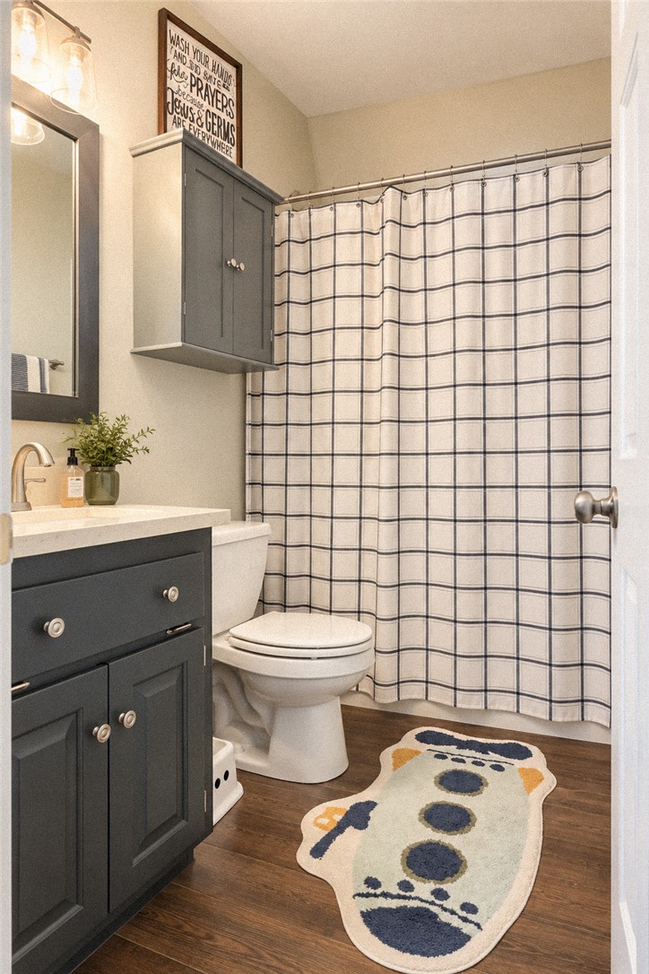 2420 Rainey Road Starr, SC 29684 - Photo 24 of 36 Rich wood-inspired flooring and a dark vanity define this classic secondary bathroom.