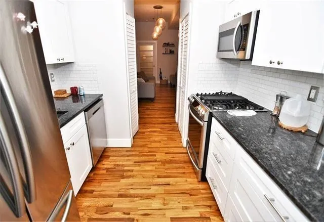 a kitchen with granite countertop a sink and a stove top oven