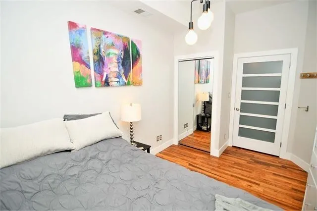 a view of a bedroom with wooden floor and window