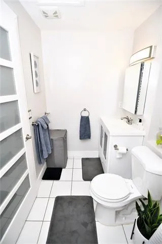 a white toilet sitting next to a bathroom sink and vanity