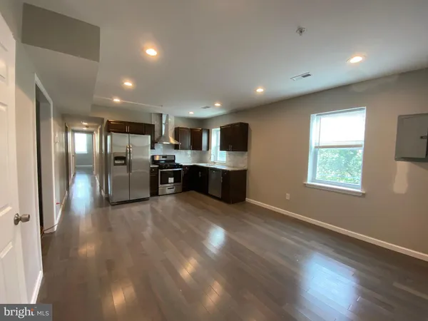 a view of kitchen with stainless steel appliances refrigerator oven and cabinets