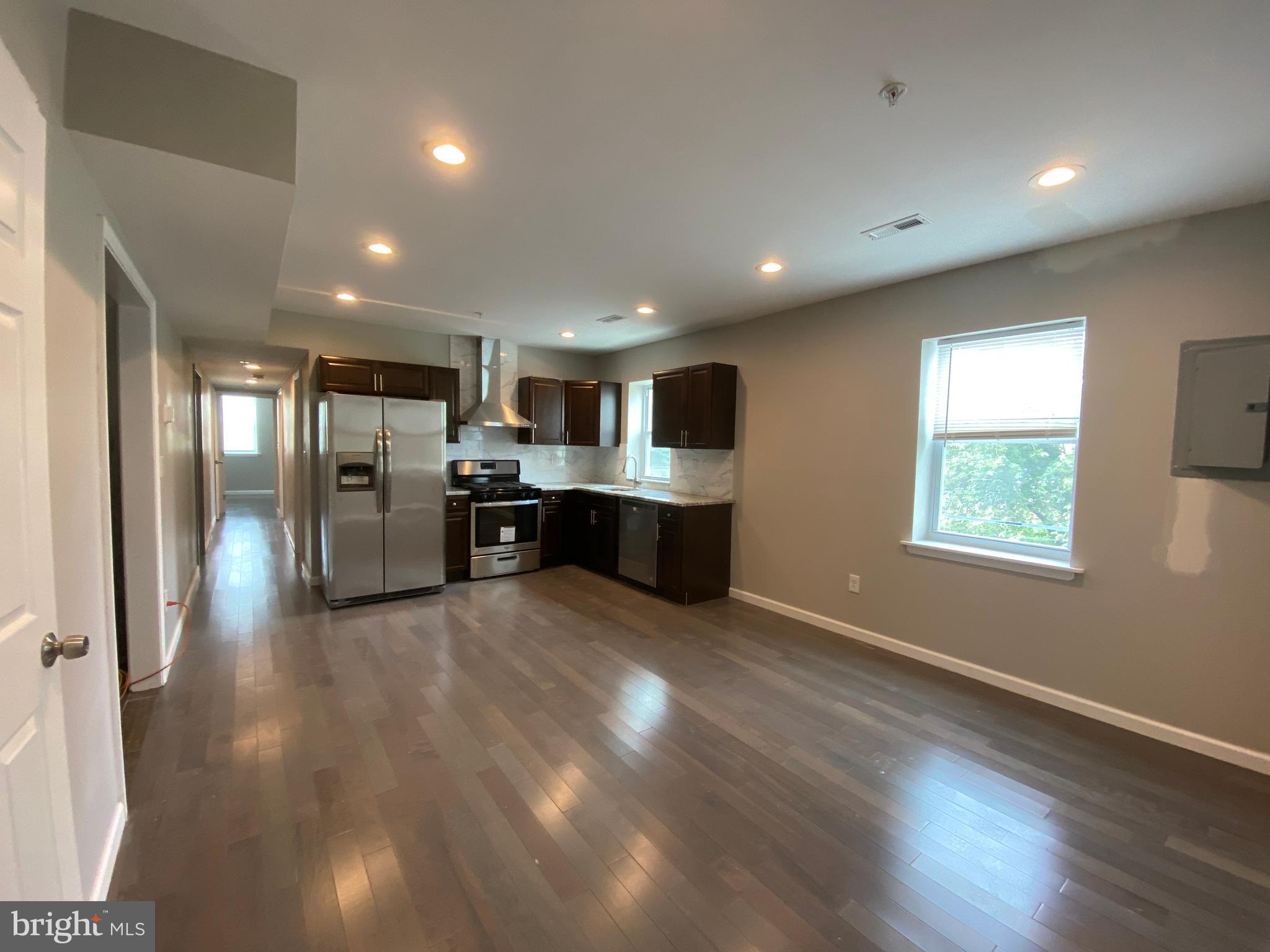 a view of kitchen with stainless steel appliances refrigerator oven and cabinets