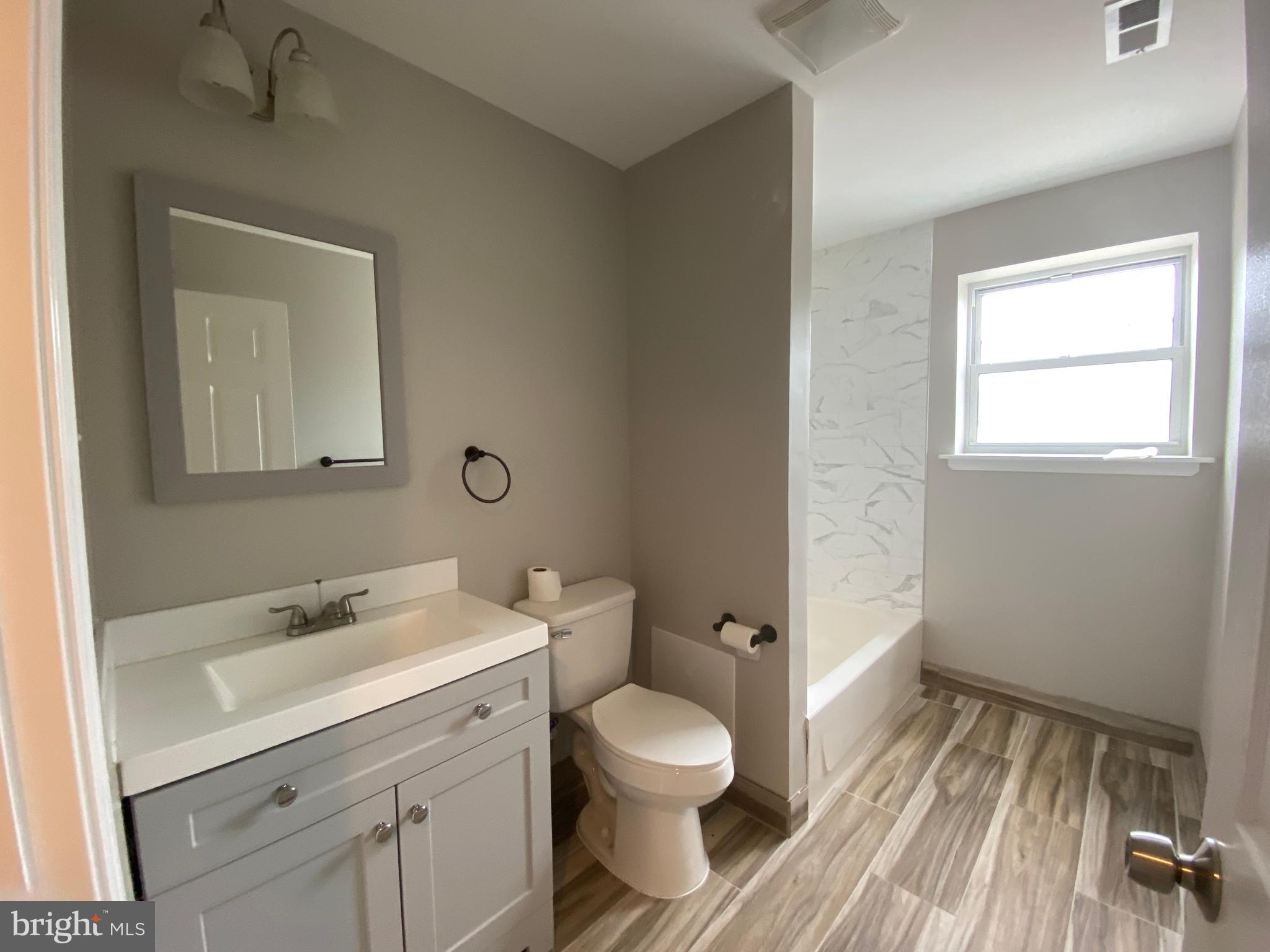 447 Diamond Street, Unit 2 Philadelphia, PA 19122 - Photo 11 of 18 a bathroom with a toilet a sink and mirror