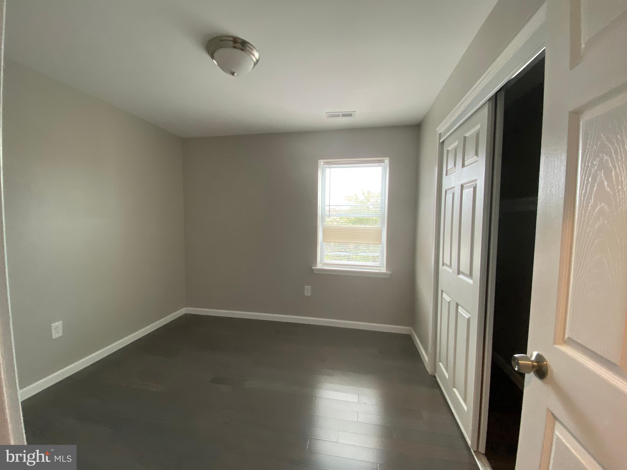 447 Diamond Street, Unit 2 Philadelphia, PA 19122 - Photo 14 of 18 an empty room with wooden floor and windows