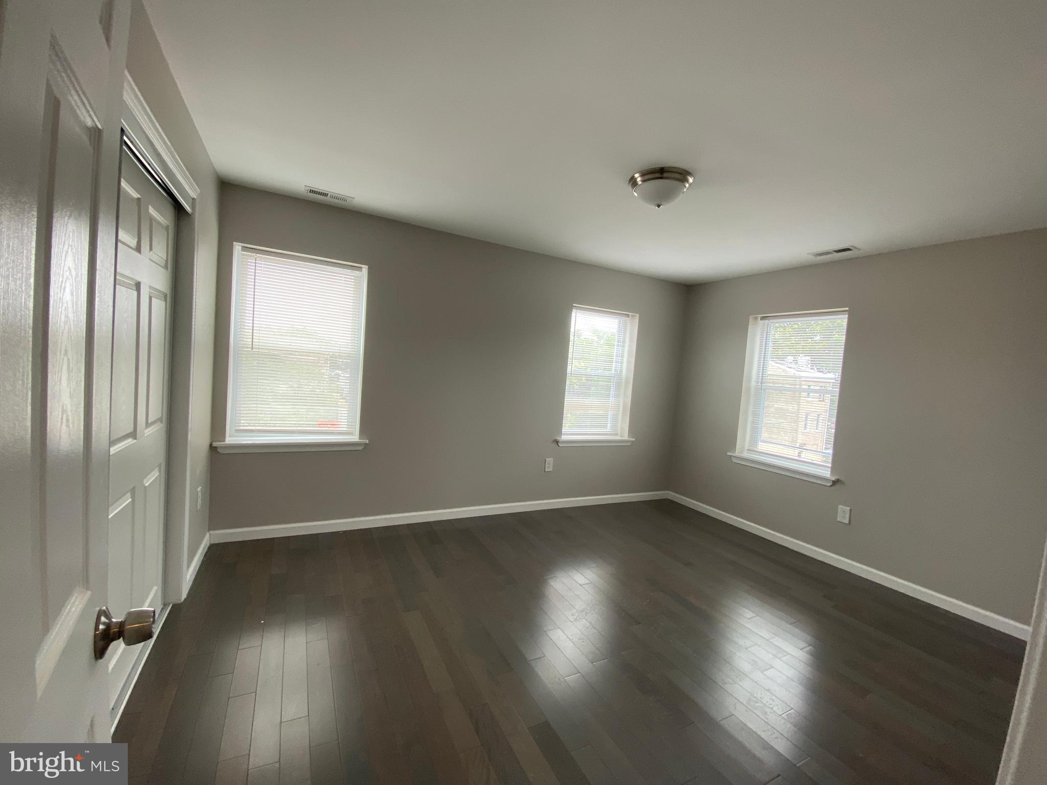 447 Diamond Street, Unit 2 Philadelphia, PA 19122 - Photo 16 of 18 an empty room with wooden floor and windows