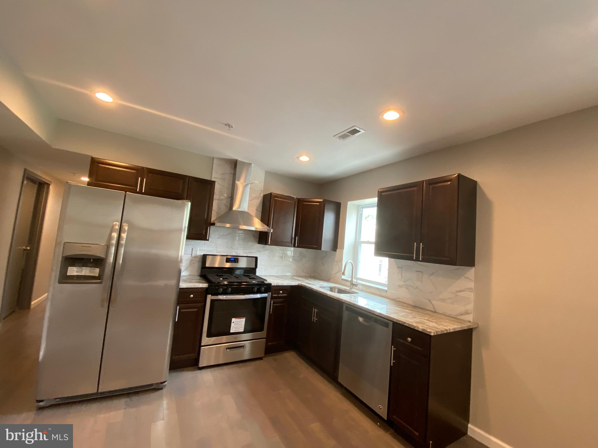 447 Diamond Street, Unit 2 Philadelphia, PA 19122 - Photo 2 of 18 a modern kitchen with stainless steel appliances granite countertop a stove a sink and a refrigerator