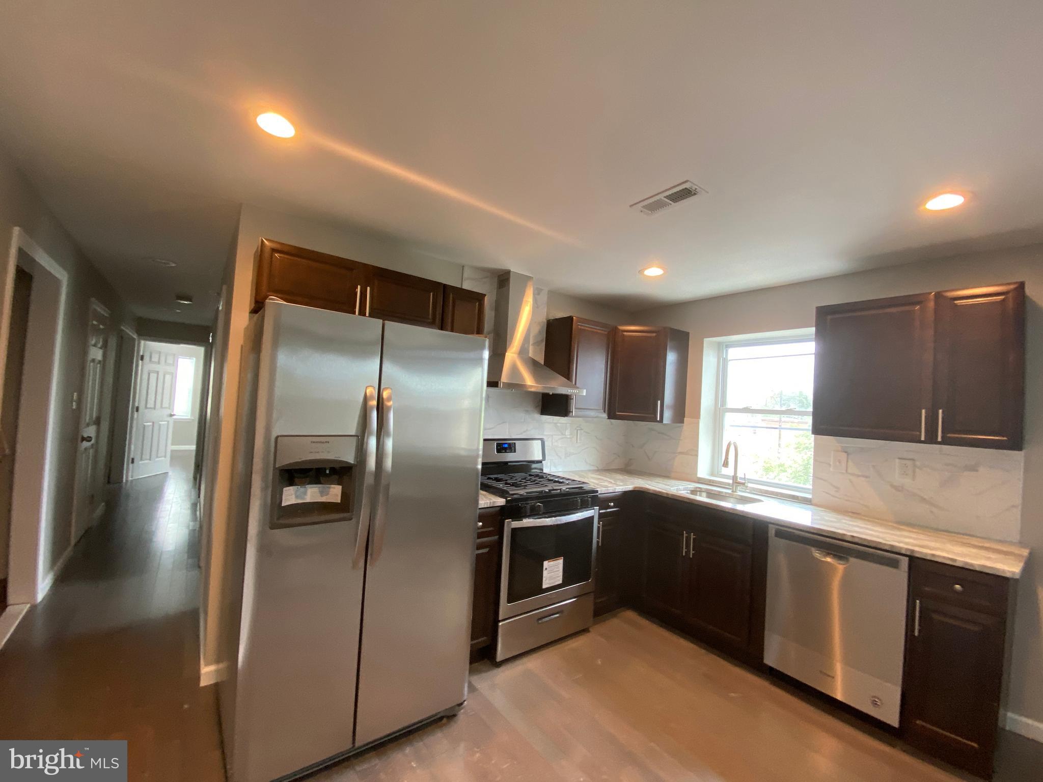 447 Diamond Street, Unit 2 Philadelphia, PA 19122 - Photo 4 of 18 a kitchen with stainless steel appliances granite countertop a sink a stove and a refrigerator