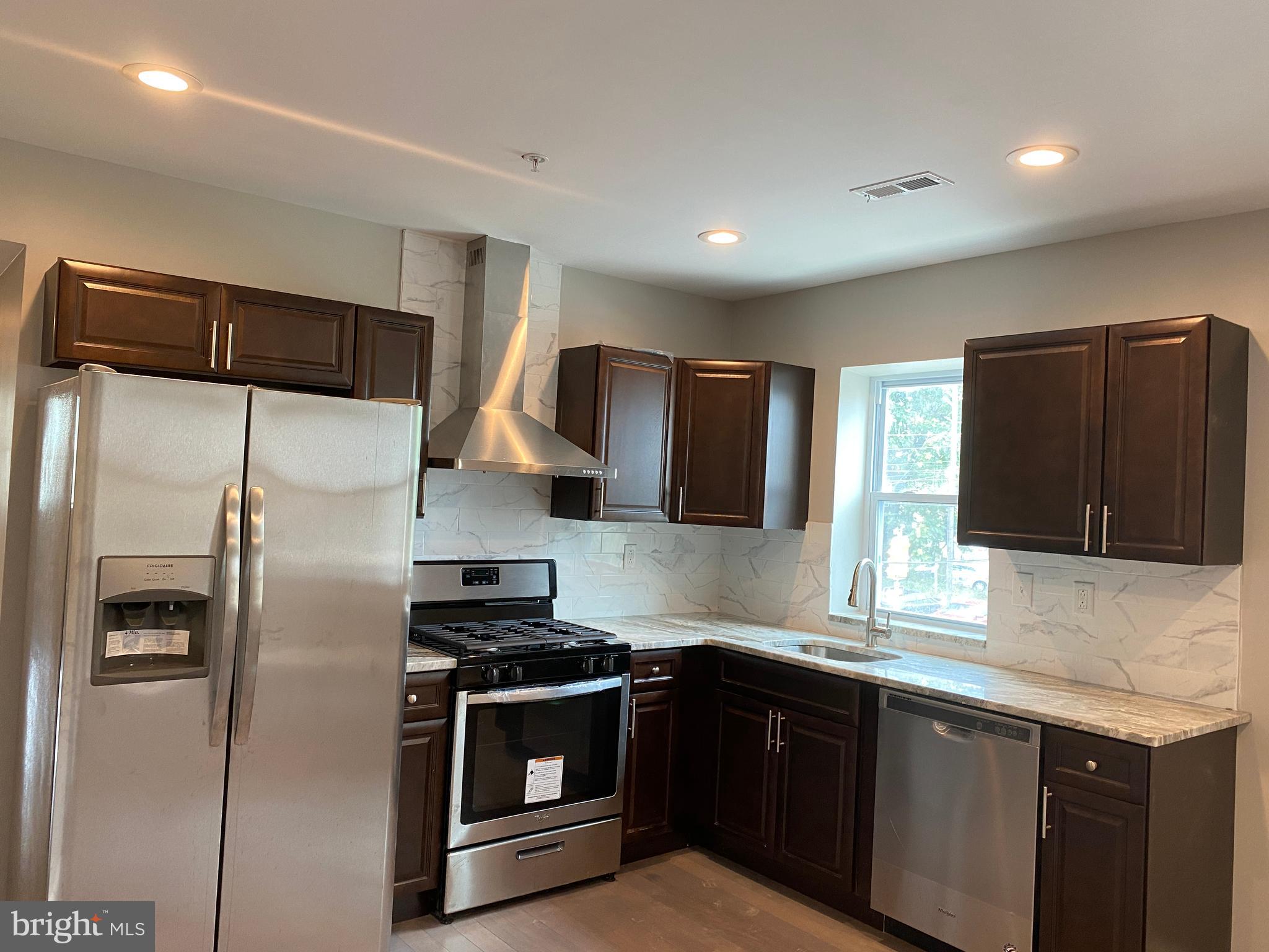 447 Diamond Street, Unit 2 Philadelphia, PA 19122 - Photo 6 of 18 a kitchen with stainless steel appliances granite countertop a refrigerator and a stove top oven
