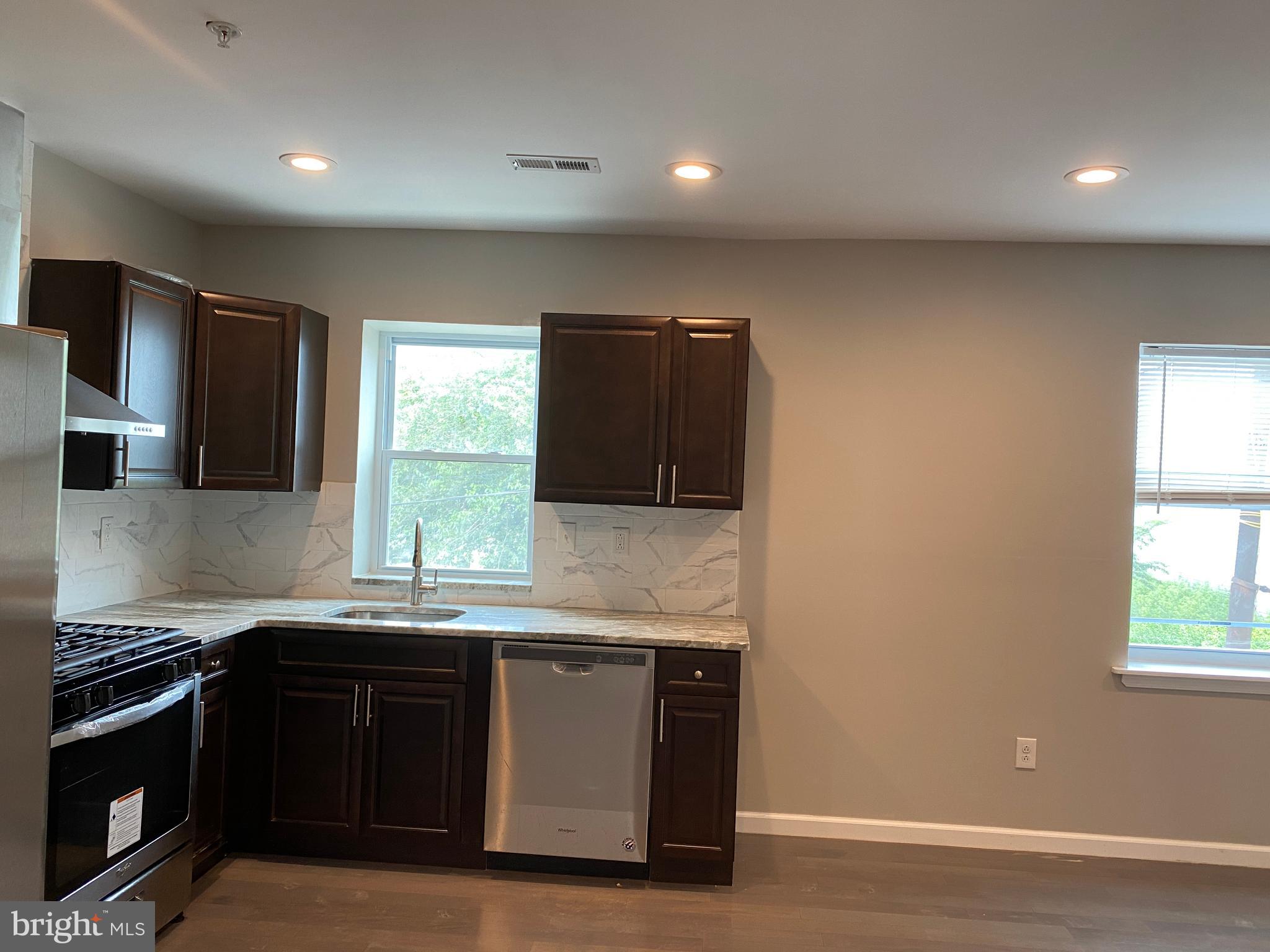 447 Diamond Street, Unit 2 Philadelphia, PA 19122 - Photo 7 of 18 a kitchen with granite countertop a sink cabinets and stainless steel appliances