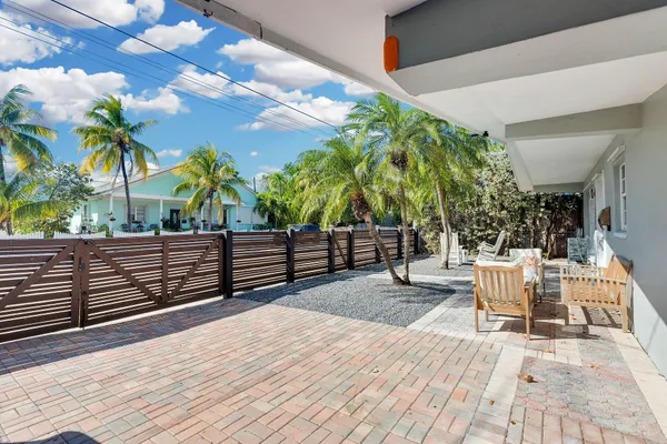 a living room with patio furniture and a potted plant