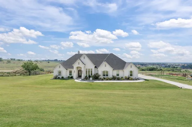 a view of a house with a big yard and large trees