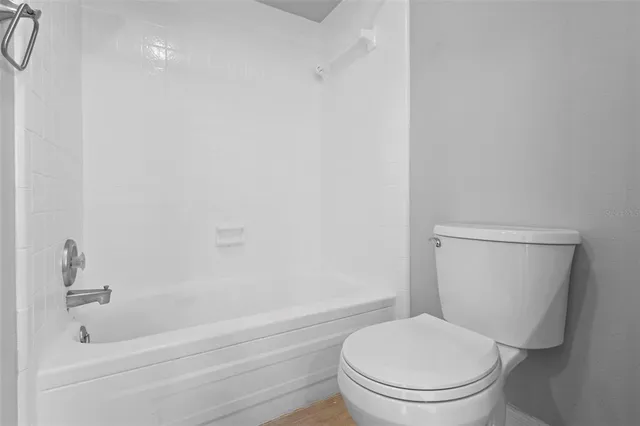 a white toilet and tub sitting next to a bathroom sink