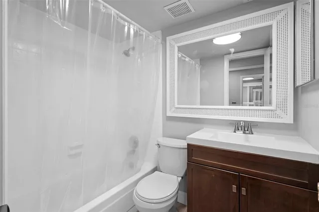 a bathroom with a sink toilet vanity and shower