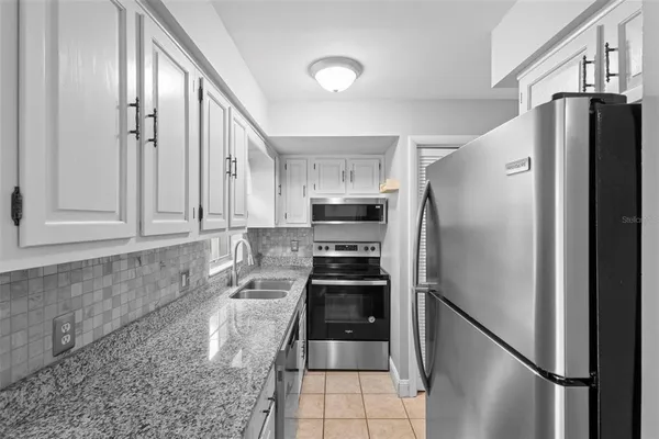 a kitchen with stainless steel appliances a refrigerator and a stove top oven