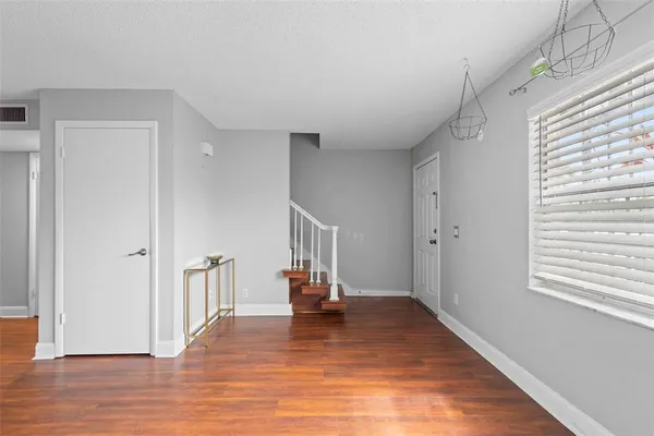 a view of a livingroom with wooden floor and a hallway