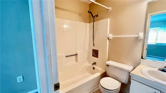 a white toilet sitting next to a bath tub
