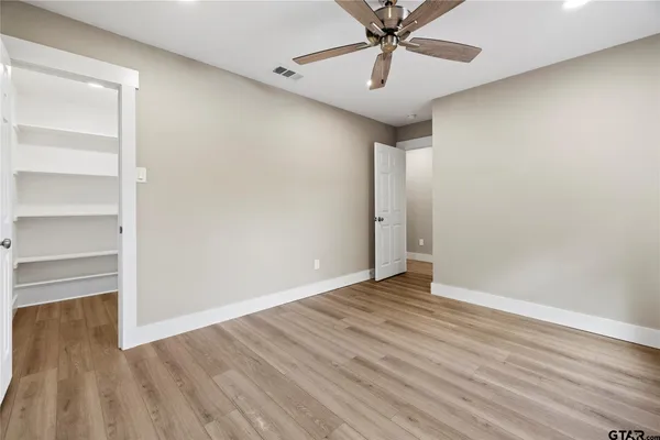 a view of an empty room with wooden floor