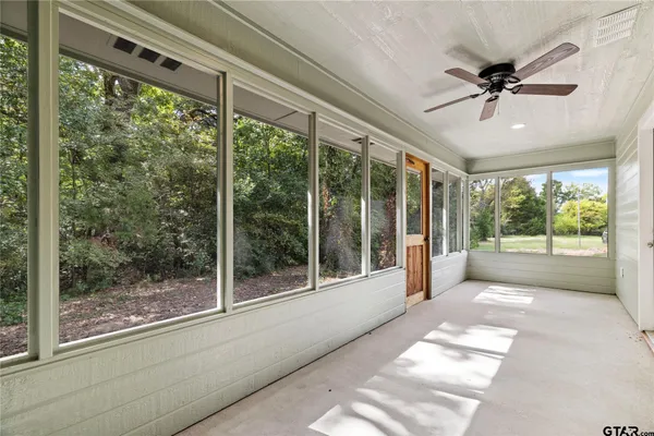 a view of a porch with a ceiling fan and a large window