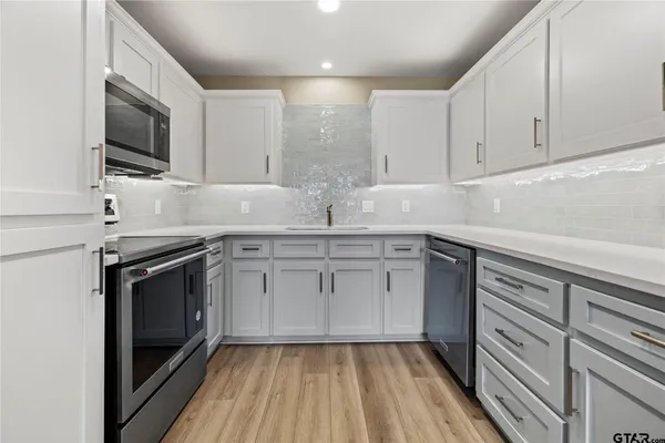 a kitchen with a sink stove and microwave