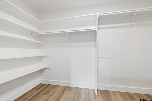 a view of walk in closet with empty racks