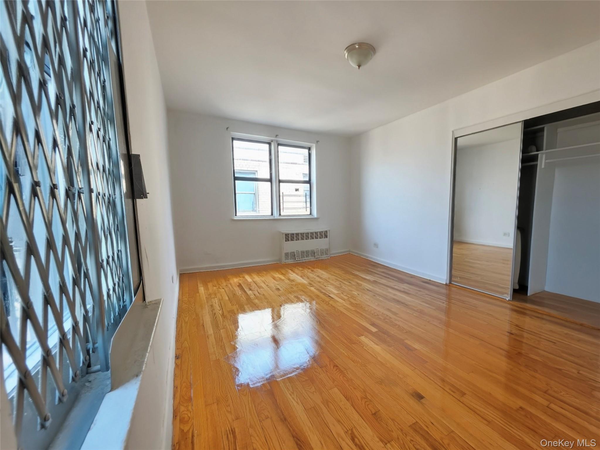 2640 Marion Avenue, Unit 6H Bronx, NY 10458 - Photo 6 of 14 wooden floor in an empty room with a window