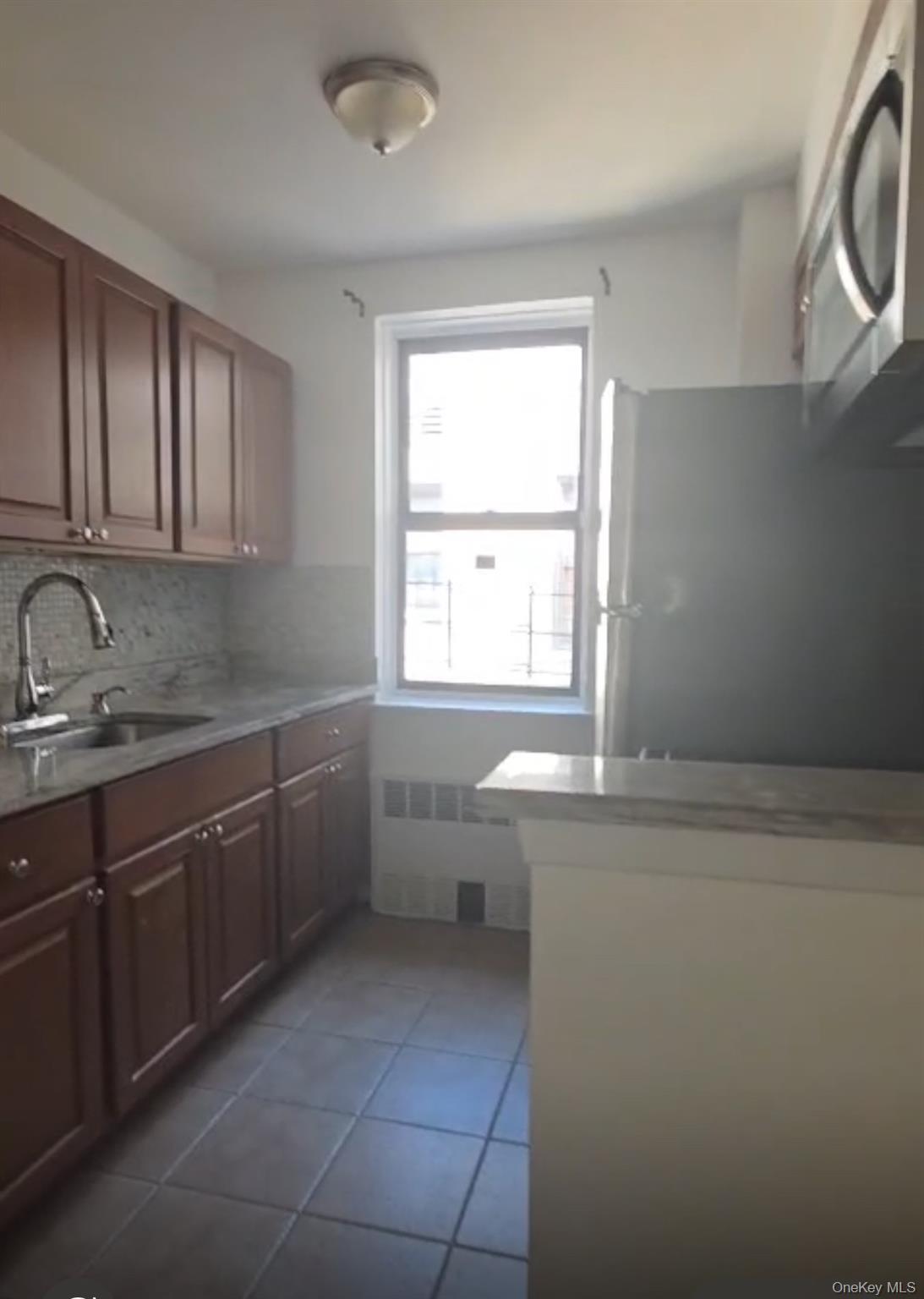 2640 Marion Avenue, Unit 6H Bronx, NY 10458 - Photo 8 of 14 a kitchen with a sink cabinets and window