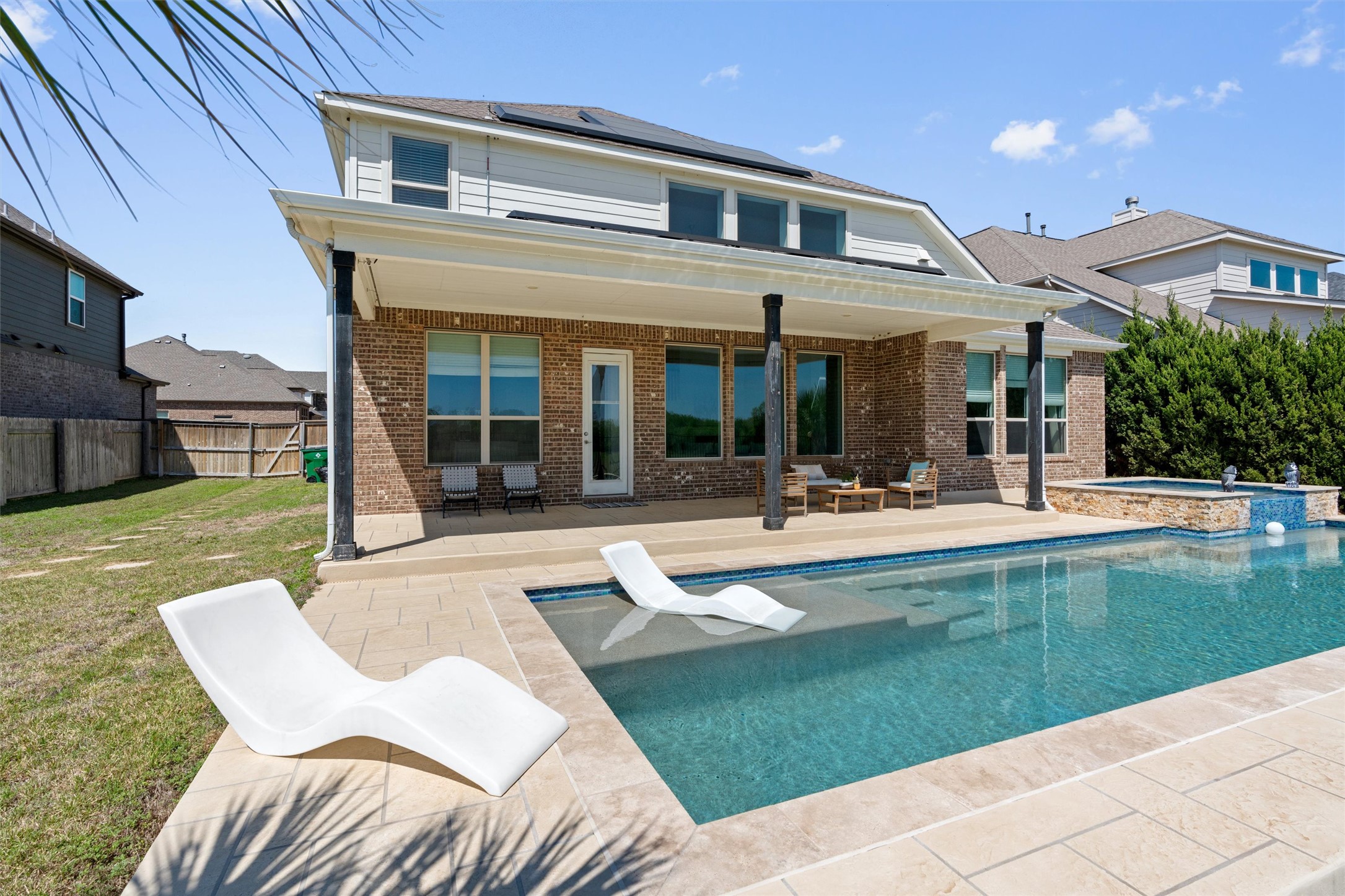 19325 Stembridge Run Pflugerville, TX 78660 - Photo 32 of 38 a view of a house with a swimming pool and a chairs in patio