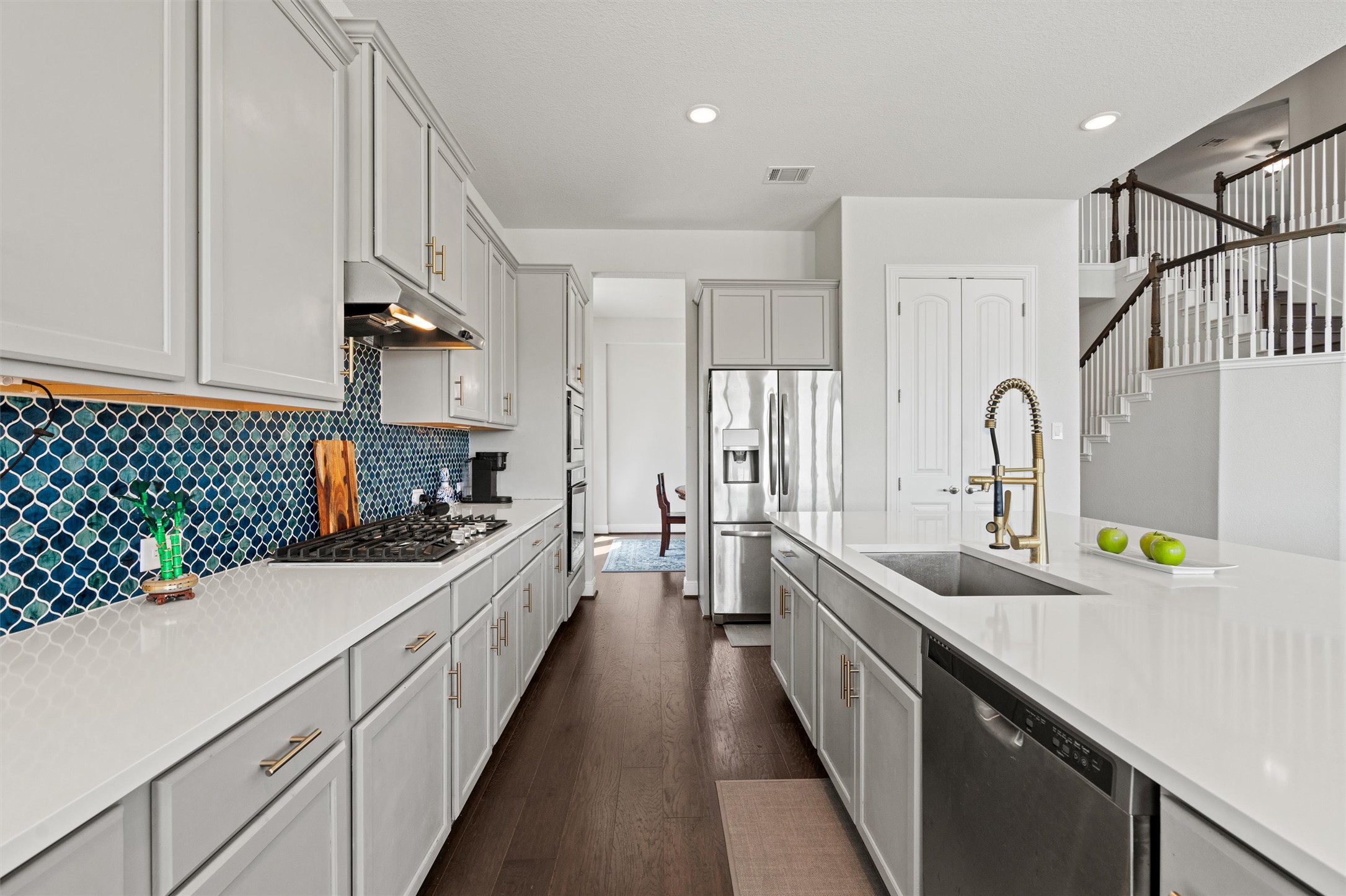 19325 Stembridge Run Pflugerville, TX 78660 - Photo 8 of 38 Kitchen featuring stainless steel appliances, dark wood-type flooring, light stone countertops, gray cabinets, and recessed lighting