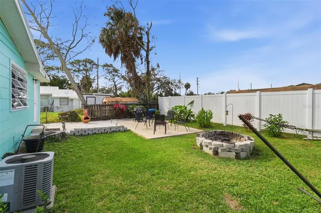 a view of a house with backyard and sitting area