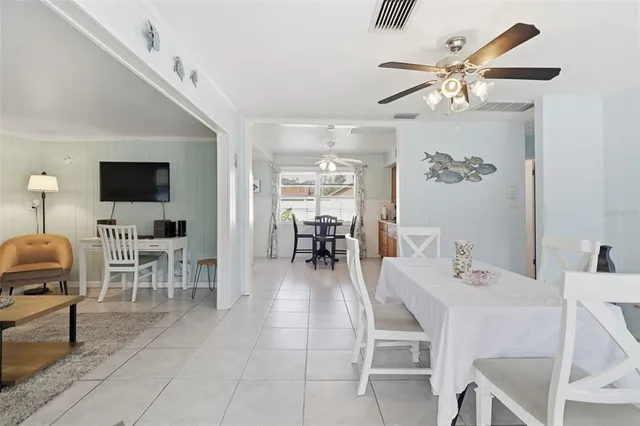 a dining room with wooden floor a chandelier a wooden table and chairs