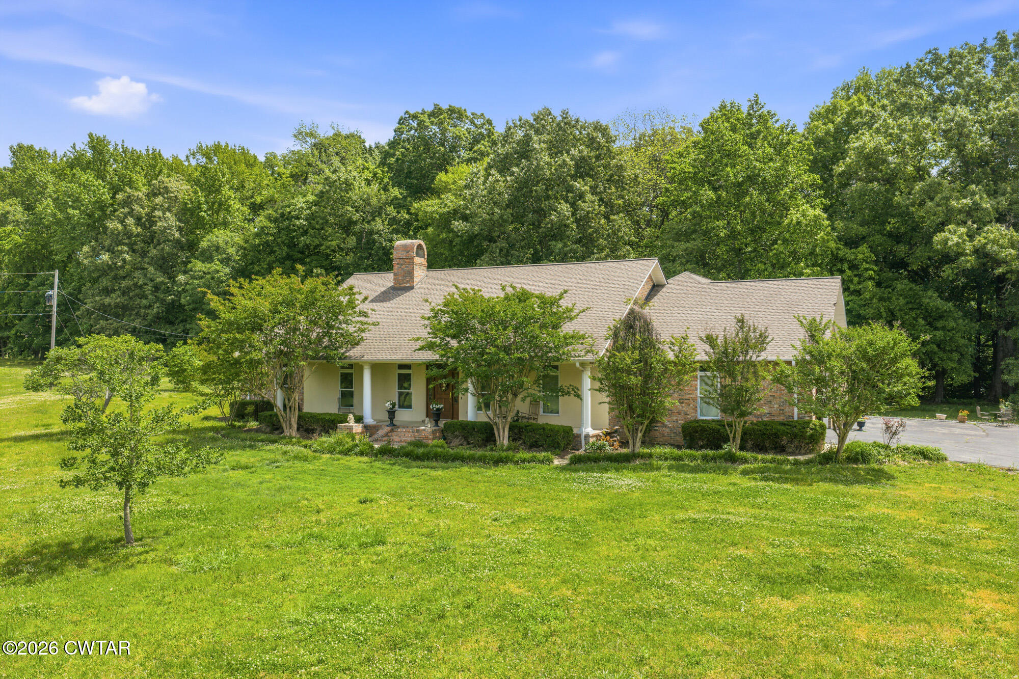 300 Harrison Road Dyersburg, TN 38024 - Photo 2 of 27 a view of a white house with a big yard and potted plants and large trees