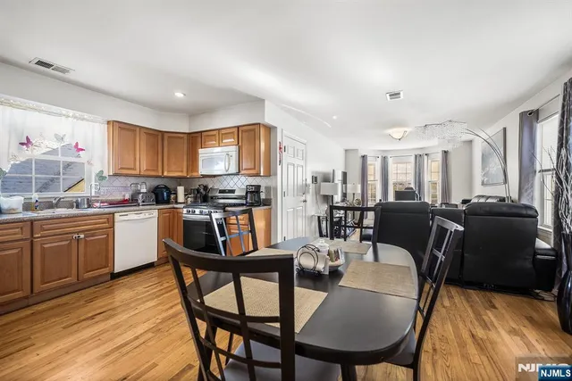a kitchen with granite countertop a table chairs microwave and cabinets