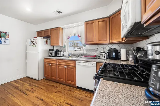 a kitchen with stainless steel appliances a stove a sink and a refrigerator