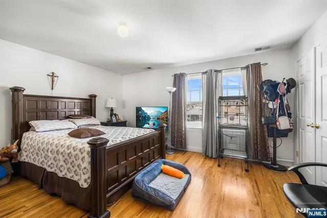 a bedroom with a bed and a wooden floor