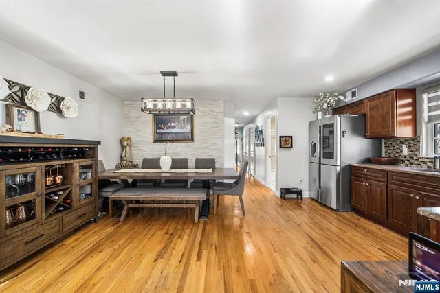 a kitchen with stainless steel appliances a dining table chairs stove and cabinets