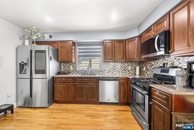 a kitchen with stainless steel appliances granite countertop a refrigerator sink and stove