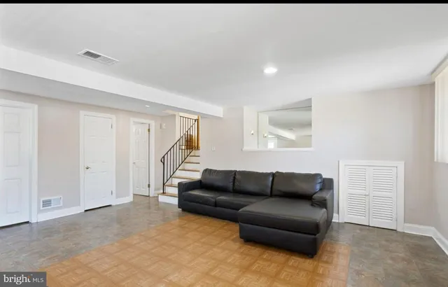 a living room with furniture and a ceiling fan