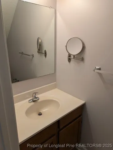 a bathroom with a sink mirror and vanity