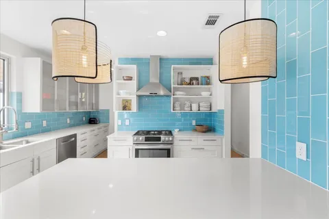 a kitchen with stainless steel appliances granite countertop a sink a stove and a refrigerator