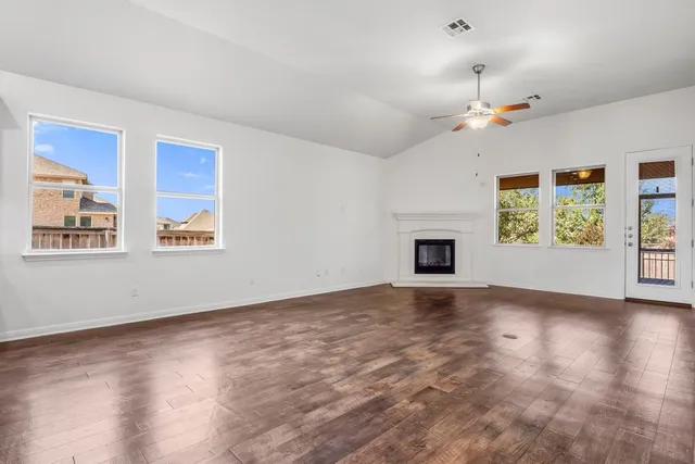 a view of an empty room with a window and fireplace