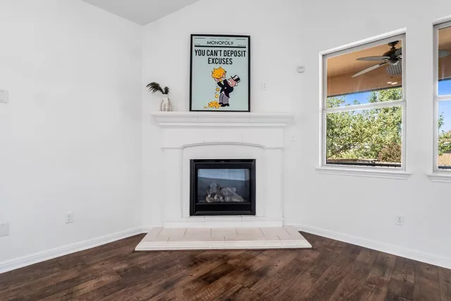 an empty room with windows and fireplace