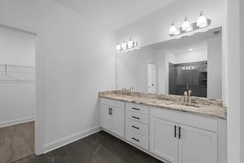 a bathroom with a granite countertop sink a large mirror and vanity