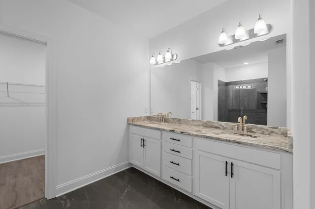 a bathroom with a granite countertop sink a large mirror and vanity