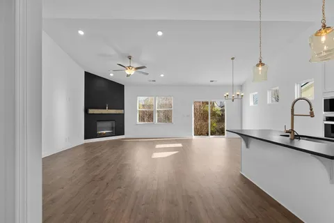 a view of an empty room with window and wooden floor