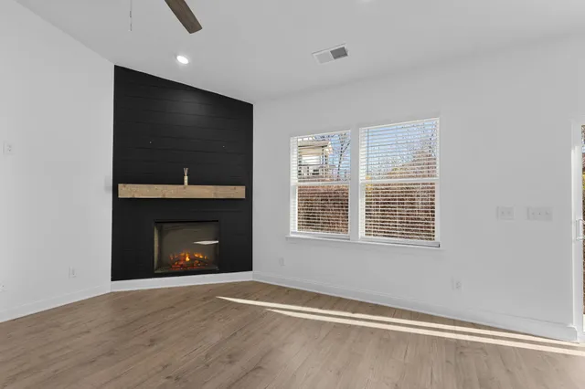 a view of an empty room with a fireplace and a window