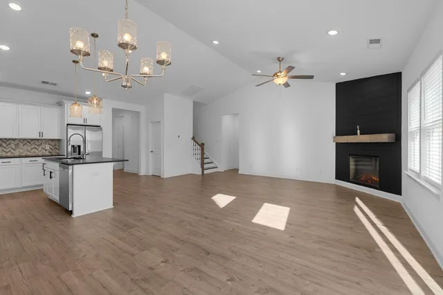 a large kitchen with kitchen island granite countertop a stove a sink a refrigerator and a fireplace