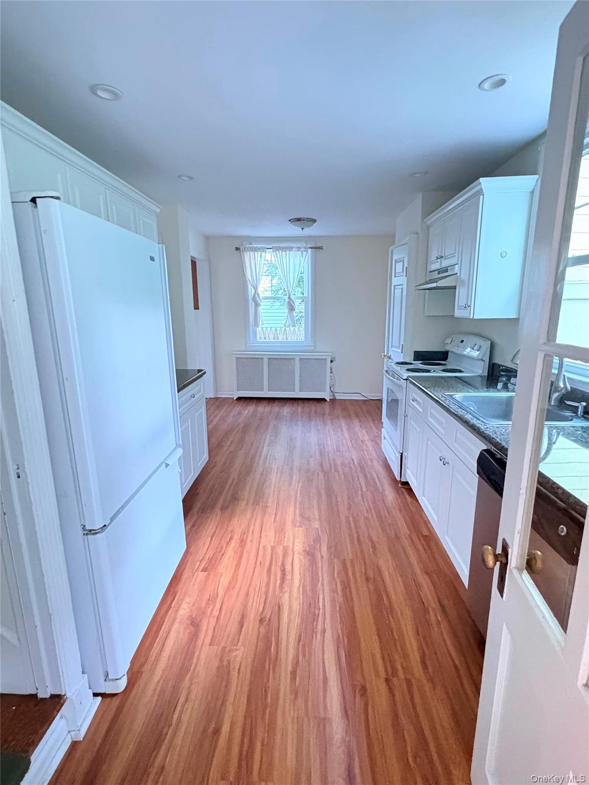 6 Tower Road Glen Cove, NY 11542 - Photo 3 of 12 a kitchen with wooden floors appliances and cabinets