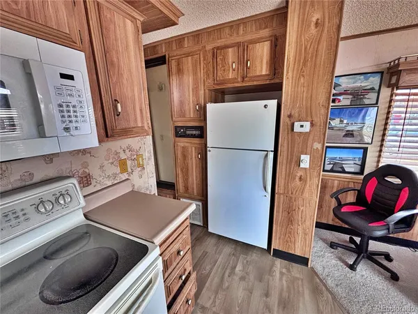 a kitchen with a refrigerator and a stove top oven